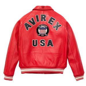 May include: A red leather jacket with the word "AVIREX" arched across the shoulders in white lettering. Below the word "AVIREX" is a circular patch with the American flag and the words "ALL AMERICANS ESTABLISHED 1975". The word "USA" is printed below the patch.