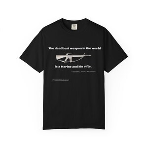 May include: Black t-shirt with the text "The deadliest weapon in the world is a Marine and his rifle." A graphic of a rifle is centered above the text. The quote is attributed to General John J. Pershing.