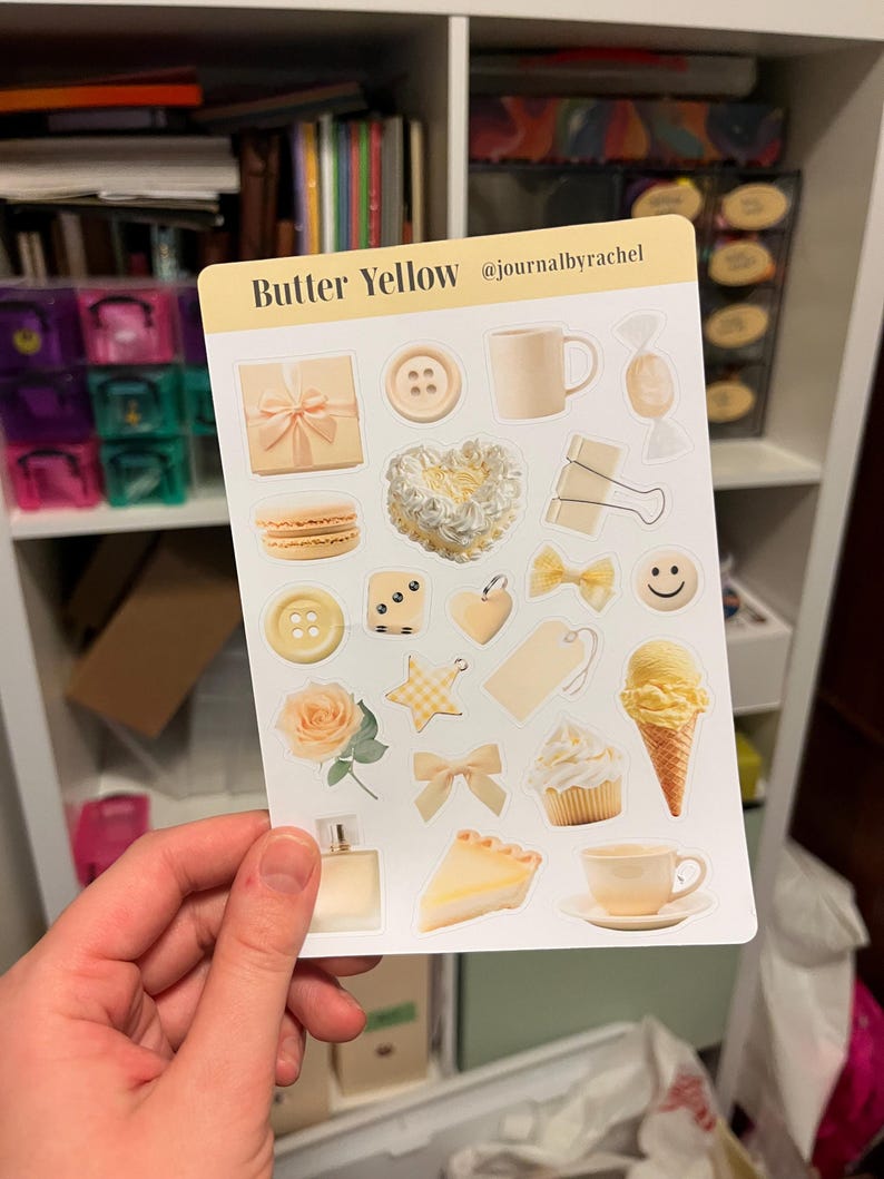 May include: A sticker sheet with various butter yellow themed illustrations, including a gift box, button, mug, candy, macaron, heart, paper clip, bow, smiley face, ice cream cone, cupcake, rose, star, perfume bottle, pie slice, and teacup. The text "Butter Yellow" is at the top.