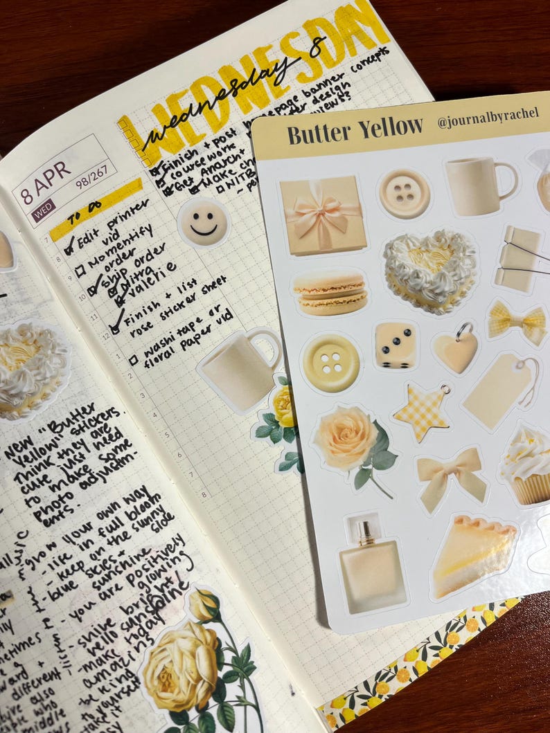 May include: A planner spread with handwritten notes and a sticker sheet labeled "Butter Yellow." The stickers include images of a gift box, buttons, a mug, a heart, a bow, a star, a perfume bottle, a macaron, a rose, and a slice of pie.