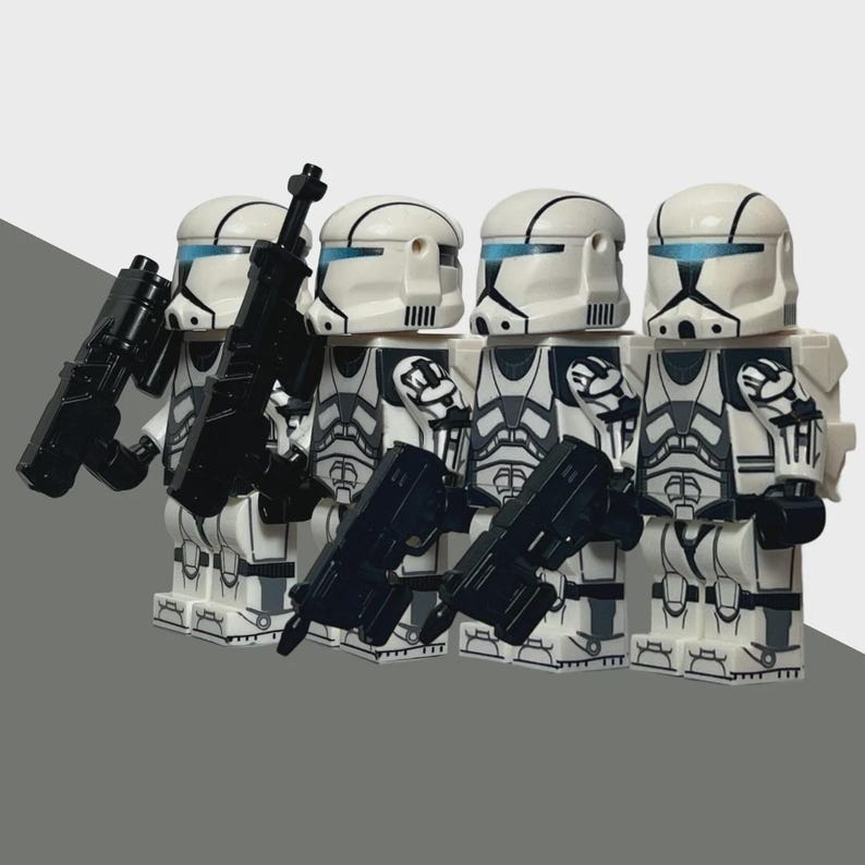 May include: Four white and gray action figures with black weapons. The figures wear white helmets with blue visors and black markings. The figures are standing in a row, each holding a black weapon.