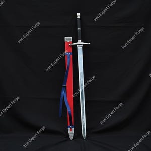 May include: A long, silver sword with a black handle and a red and blue scabbard. The sword is displayed vertically against a black backdrop. The text "Iron Expert Forge" is repeated around the image.