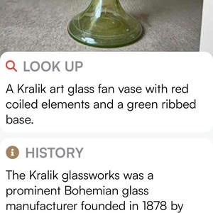 May include: A Kralik art glass fan vase with a green ribbed body and a flared top. The vase has a round base and features red coiled elements. This decorative art glass piece is a unique collectible.