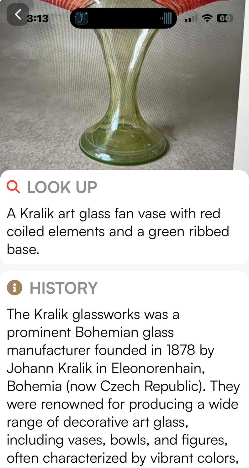May include: A Kralik art glass fan vase with a green ribbed body and a flared top. The vase has a round base and features red coiled elements. This decorative art glass piece is a unique collectible.