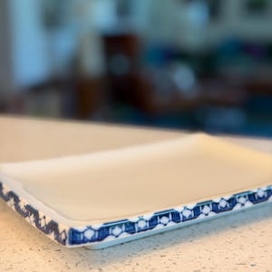 May include: A white ceramic mug with a black handle and the text "But First, Coffee" in a black, bold font. The mug is sitting on a wooden surface. The mug is approximately 4 inches tall.