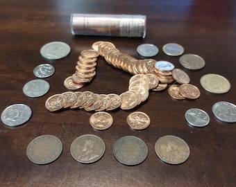 May include: A collection of silver and copper coins, including Canadian pennies, nickels, and dimes. The coins are arranged in a circle around a roll of coins.