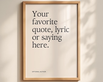Può includere: Una stampa incorniciata con il testo "Your favorite quote, lyric or saying here" in nero su sfondo crema. Il testo è in un carattere sans-serif. La cornice è in legno chiaro. Il testo "OPTIONAL AUTHOR" è in basso.