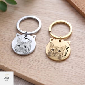 Può includere: Due portachiavi personalizzati a forma di gatto. Uno è argentato con il nome "Lime", l'altro dorato con "Tomasito". Ogni portachiavi presenta un ritratto inciso dettagliato di un gatto e un anello.