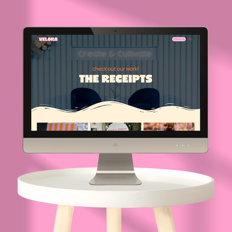 May include: A computer monitor displaying a website with the text Velora, Create & Cultivate, check out our work!, and THE RECEIPTS. The screen features a cream-colored wavy graphic element over a dark background with two dark blue chairs.