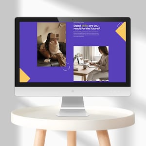 May include: A modern computer monitor displays a presentation with the text "Digital skills: are you ready for the future?" The screen shows images of people using laptops and taking notes. The monitor sits on a white table.