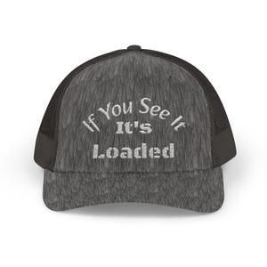 Puede incluir: Gorra de camionero gris con parte trasera de malla y visera curva. La parte delantera de la gorra presenta el texto bordado en blanco "If You See It, It's Loaded". Un accesorio informal.