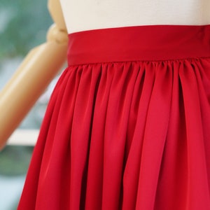 May include: A red satin skirt with a gathered waistband.