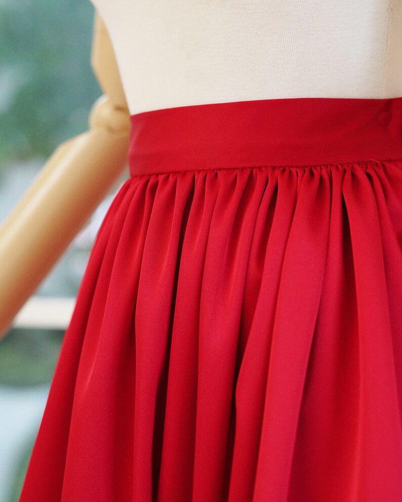 May include: A red satin skirt with a gathered waistband.