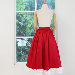 May include: A red skirt with a white lace trim. The skirt is full and has a gathered waist.