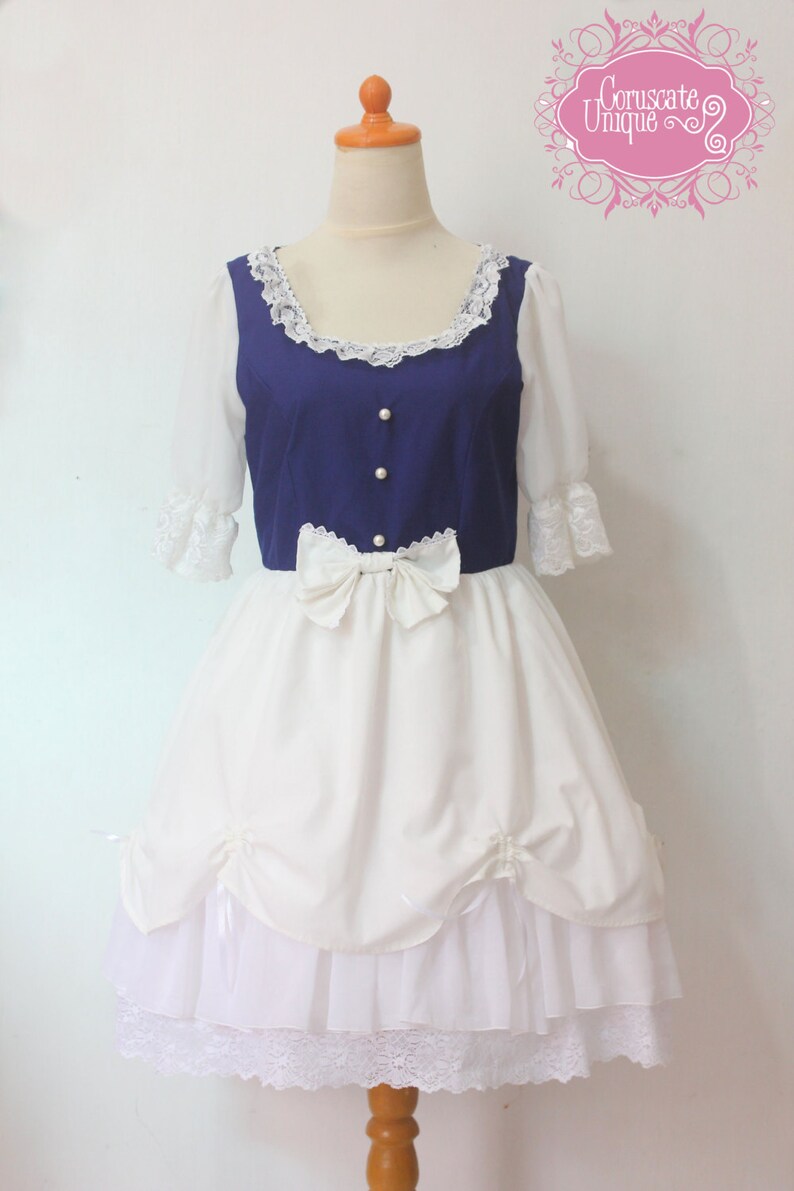 May include: A white and blue dress with a blue bodice and a white skirt. The bodice has a lace neckline and pearl buttons. The skirt has a white bow at the waist and a white lace trim at the bottom.
