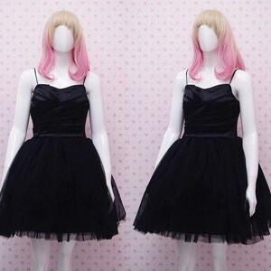 May include: A black tulle dress with a satin bodice and a sweetheart neckline.