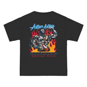 Könnte beinhalten: Schwarzes T-Shirt mit einem Motiv einer muskulösen Figur, dem Text "ANTING-ANTING" in Blau und "FILIPINO Spiritual Power" in Rot. Das Design beinhaltet Flammen und eine stilisierte Illustration.