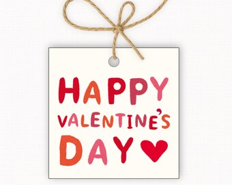 May include: A square, off-white gift tag with the words "HAPPY VALENTINE'S DAY" in red, pink, and orange lettering, and a red heart. A natural twine bow is attached at the top.