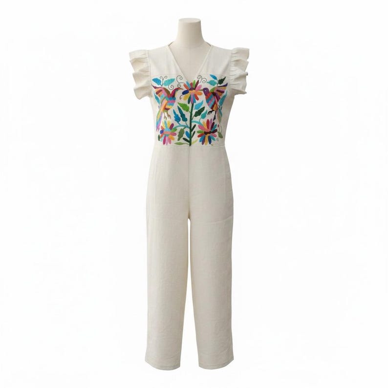 May include: An off-white sleeveless jumpsuit featuring a V-neckline and ruffled cap sleeves. The bodice is decorated with a vibrant, multi-coloured floral and bird embroidery pattern. The garment has a straight-leg silhouette and a fitted waist.