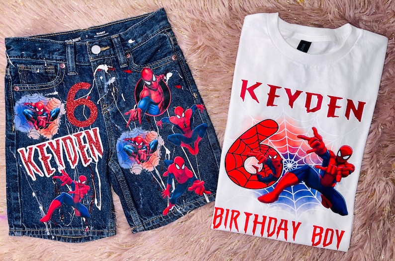 Peut inclure: Un short en jean bleu fonc&eacute; et un t-shirt blanc avec des motifs Spider-Man. Le short pr&eacute;sente un chiffre 6 rouge &agrave; paillettes, le nom KEYDEN et des &eacute;claboussures de peinture blanche. Le t-shirt affiche le nom KEYDEN, un chiffre 6 rouge et BIRTHDAY BOY.