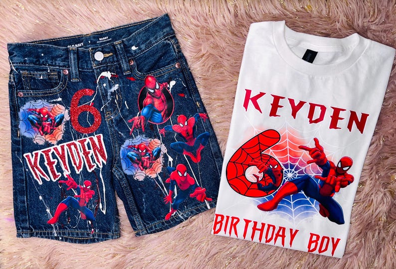 Peut inclure: Un short en jean bleu fonc&eacute; et un t-shirt blanc avec des motifs Spider-Man. Le short pr&eacute;sente un chiffre 6 rouge paillet&eacute;, le nom KEYDEN et des &eacute;claboussures de peinture blanche. Le t-shirt affiche le nom KEYDEN, un chiffre 6 rouge et BIRTHDAY BOY.