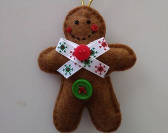 May include: A brown gingerbread man ornament with a white ribbon with green and red snowflakes, a red button, and a green button.