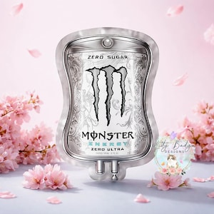 May include: A silver-toned, medical IV bag-shaped novelty item featuring the black Monster Energy logo, the text ZERO SUGAR, and ZERO ULTRA. The design includes intricate grey filigree patterns on a white background with a metallic border.
