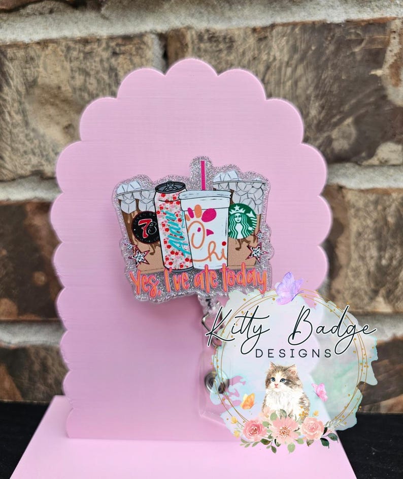 May include: A glittery acrylic badge reel featuring a graphic of three beverage cups and the text Yes, I've ate today. The design includes a 7-Eleven cup, a soda can with the name Allan, and a Chick-fil-A cup with a Starbucks logo nearby.