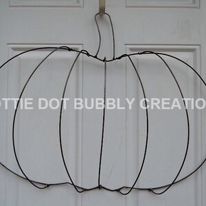 Op de afbeelding: Een metalen draadpompoenkransframe. Het frame is gemaakt van draad en is gevormd als een pompoen. Het is een geweldige manier om een ​​toets van herfstdecoratie aan uw huis toe te voegen.