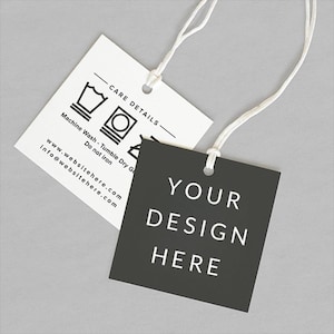 May include: Two clothing tags with white strings. One tag is black with the text "YOUR DESIGN HERE" in white. The other tag is white with care symbols and the text "CARE DETAILS" and "Machine Wash - Tumble Dry Ga Do not iron".