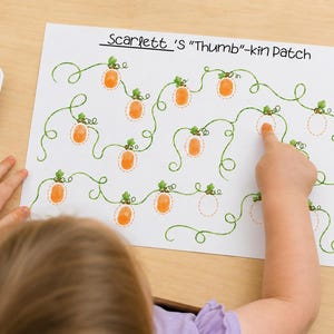 May include: A white paper activity sheet titled Scarlett's Thumb-kin Patch featuring green illustrated pumpkin vines with empty orange dashed outlines for thumbprints, accompanied by a small square dish of orange paint.