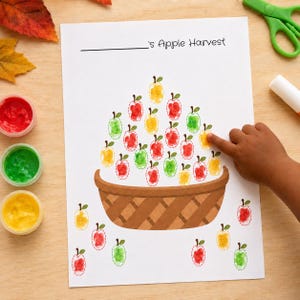 Könnte beinhalten: Ein weißes Arbeitsblatt mit dem Titel 's Apple Harvest, das einen braunen Korb mit roten, grünen und gelben Fingerabdruck-Äpfeln zeigt. Weitere Fingerabdruck-Äpfel sind um den Korb herum auf dem Blatt verteilt.