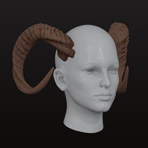 May include: A white mannequin head with brown horns attached. The horns are curved and textured, with a ridged appearance. The head has no facial features, and the background is a solid black.