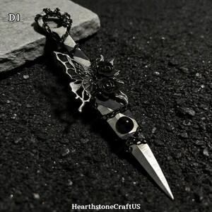 May include: A silver dagger with a black handle, adorned with a butterfly, roses, and a black gem. The dagger is embellished with a chain and has a sharp, pointed blade. The text "D1" is in the upper left corner.