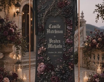 Może przedstawiać: Czarna pionowa tablica ślubna zawieszona na miedzianej metalowej ramie, zawierająca tekst Camille Hutchison + Braden Michaels oraz October 28, 2026, otoczona ciemnoczerwonymi i fioletowymi kompozycjami kwiatowymi z czarnymi wstążkami.