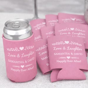 Pink personalized wedding can coolers printed with Love and Laughter theme, couple names, and happily ever after message. A popular choice for romantic weddings, bridal showers, and engagement celebrations. Crafted from quality neoprene for a snug fit on cans and bottles. Designed as reusable favors that enhance table settings and bar displays. Made to order and sold in bulk, these drink sleeves help create a cohesive event aesthetic while giving guests a keepsake they will actually use.