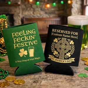 May include: Two beer can coolers, one green and one black, with gold lettering. The green cooler reads "FEELING FECKIN' FESTIVE" and "A Wee Drop of Irish Magic." The black cooler says "RESERVED FOR [Custom Name Here]" and "ST. PATRICK'S DAY."