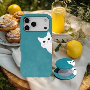 May include: A teal smartphone case featuring a white cat illustration peeking from the side, paired with a matching circular phone grip that displays the same white cat design on a teal background, creating a cohesive set for mobile devices.