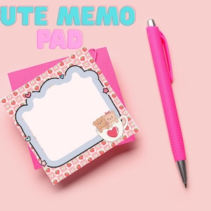May include: A pink memo pad with a strawberry pattern and a light blue border, featuring a cartoon bear in a cup. A pink pen is next to the memo pad. The text "CUTE MEMO PAD" is at the top of the image.