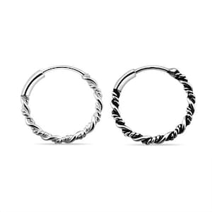 May include: A pair of silver-colored hoop earrings. Each earring features a twisted rope design around the hoop. The earrings are shown against a white background.