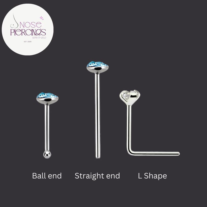 May include: Three silver nose piercings with different end designs: a ball end, a straight end, and an L-shape. The ball end features a light blue gemstone. The straight end has a light blue gemstone. The L-shape has a clear gemstone. The text "Nose Piercings" is in a circle.