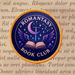 May include: A circular embroidered patch with a gold border featuring a dark blue background, a purple crescent moon, a silver sword, and an open book with purple wings. The text ROMANTASY BOOK CLUB is printed in white around the central design.