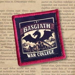 May include: A square embroidered patch with a dark blue center and a vibrant magenta border. The design features a black silhouette of a dragon above a castle, with the text BASGIATH in a banner and WAR COLLEGE printed below in white.