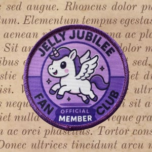May include: A circular purple patch with the text "JELLY JUBILEE FAN CLUB" and a cartoon unicorn with wings. The unicorn is white with purple accents. The patch also says "OFFICIAL MEMBER".