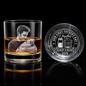 May include: A personalized whiskey glass with a photo of a father and baby, filled with amber liquid. Beside it, a coaster with the text "OUR FIRST FATHER'S DAY together" and the names "HENRY & DADDY" and the year "2026".