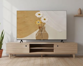 May include: A flat-screen TV displays a floral art print. The artwork features a vase with white and yellow flowers, with the word "Sunshine" in script. The TV sits on a light wood media console with two doors and open shelving.