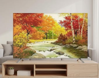 May include: A flat-screen television displays a vibrant landscape painting of a river flowing through a forest. The artwork features trees with red, orange, and yellow foliage, suggesting an autumn scene. The TV is set on a light wood entertainment center.