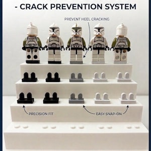 May include: A display of minifigure heel savers in black, gray, and white, designed to prevent heel cracking. The image includes text that reads "MINIFIGURE HEEL SAVERS - CRACK PREVENTION SYSTEM" and "COLLECT WITH CONFIDENCE - PROTECT THE VALUE OF YOUR MINIFIGS."