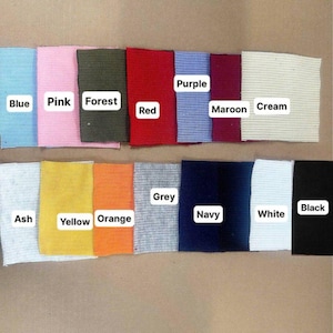 May include: A collection of rectangular fabric swatches arranged in two rows, featuring colors labeled as Blue, Pink, Forest, Red, Purple, Maroon, Cream, Ash, Yellow, Orange, Grey, Navy, White, and Black. Each swatch has a visible ribbed texture.
