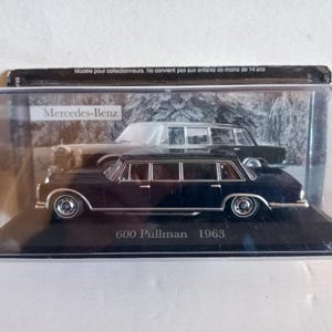 Könnte beinhalten: Ein schwarzes Mercedes-Benz 600 Pullman Modellauto von 1963, präsentiert in einer transparenten Vitrine. Das Modellauto ist eine Miniatur des klassischen Luxusfahrzeugs. Auf der Vitrine steht "Mercedes-Benz" und "600 Pullman 1963".